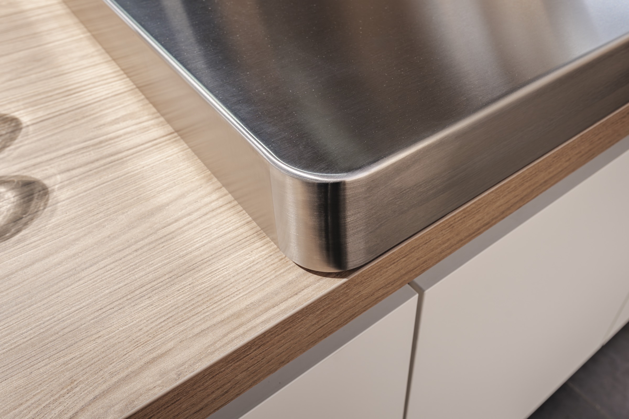 Detail van RVS opstand op eiken werkblad